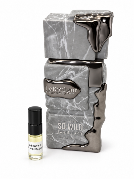 Le Bonheur So Wild Boulder fragrance bottle and black-capped sample vial on white