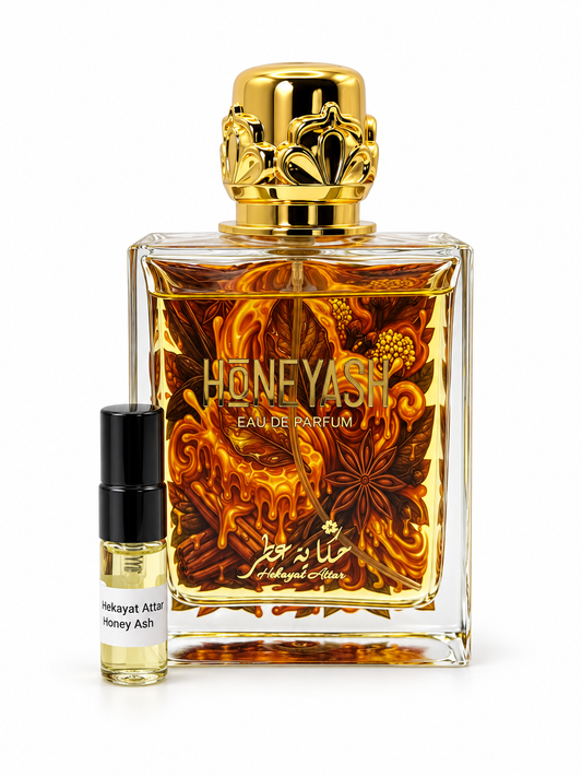 Hekayat Attar Honeyash fragrance bottle and black-capped sample vial on white